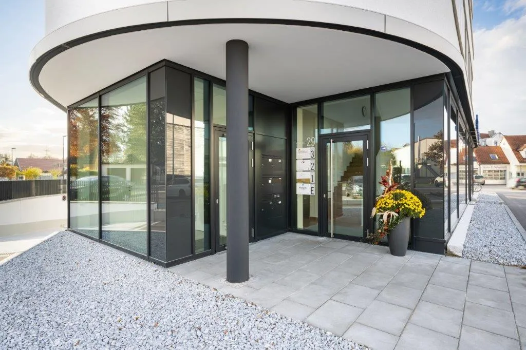 Eingang des runden Neubaus mit Glasfront