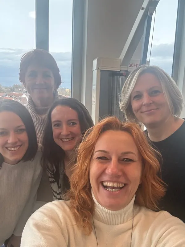 Fünf Frauen aus dem Lenergo-Team beim gemeinsamen Selfie vor großen Fenstern mit Blick über Aichach
